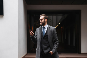 Attractive young businessman wearing suit walking