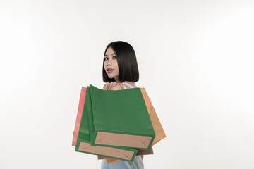 Shopping concept. Beautiful girl is carrying a bag on a white background. Asian girls are buying things happily.