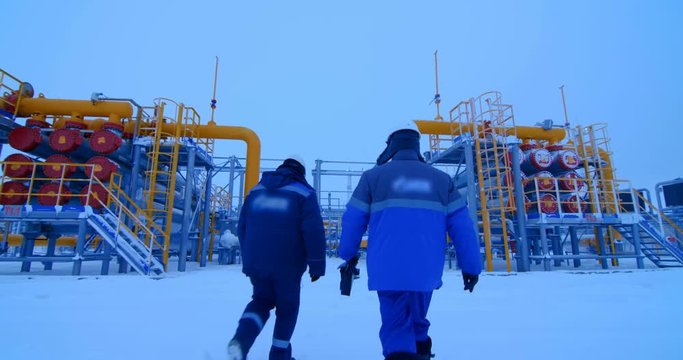 Workers in the gas and oil industries go to the pipelines of the oil and gas complex. Cold winter outside, snow everywhere