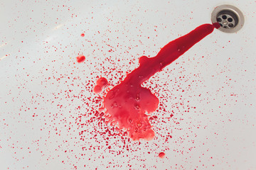 Splashes of blood dripping into the sink in the bathroom.