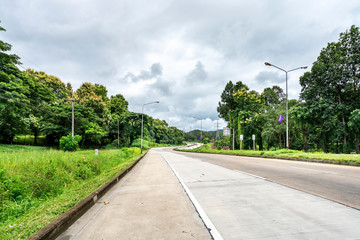 Beauty empty highway road with lamp post and tree on cloudy sky background