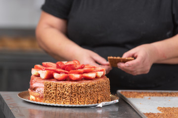 Close up of Professional confectioner making a delicious cake in the pastry shop .