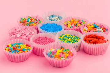 Sugar sprinkles, decoration for cake and ice-cream and cookies on pink background