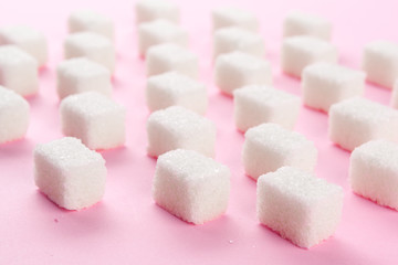Cubes of sugar on bright pink background