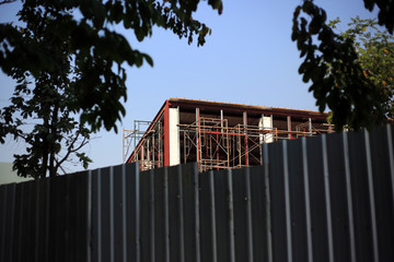 Fototapeta premium Structure building and scraffoldings in site construction with metal wall for safety work.