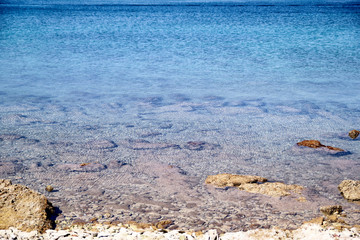 Exotic rocky beach, tropical blue mediterranean sea with waves and sea foam. Beautiful natural environment, panorama, landscape. Idyllic seaside resort in summer season, paradise and amazing scene.
