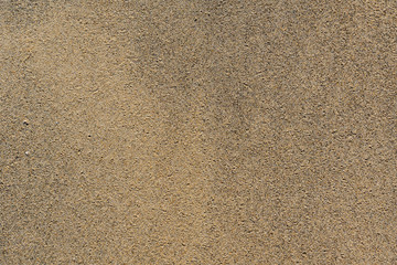 Fototapeta na wymiar Top view of a small flat fine damp sand on tropical beach on sunny day during summer time background texture. 