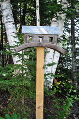 A Handmade Birdhouse Made of Wood on a Rock Wall in the Country