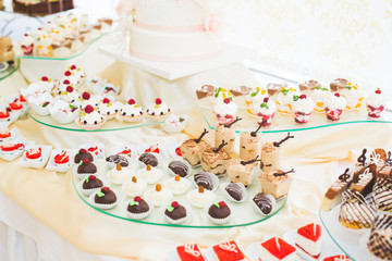 Fototapeta na wymiar Delicious sweets on wedding candy buffet with desserts, cupcakes