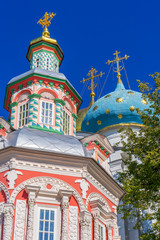 Fototapeta na wymiar Chapel and domes of Dormition Cathedral or Uspensky sobor of Holy-Trinity St. Sergius Lavra against blue sky. Sergiyev Posad, Moscow region, Golden ring of Russia. UNESCO World Heritage Site