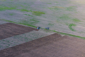 Obraz premium Top view of the tractor that plows the field. disking the soil. Soil cultivation after harvest