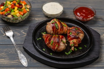 Fried chicken legs wrapped in bacon. The view from the top. Copy-space.
