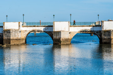 Old roman bridge over Gilao river in Tavira, Algarve, Portugal