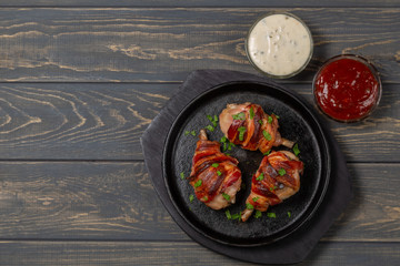 Fried chicken legs wrapped in bacon. The view from the top. Copy-space.