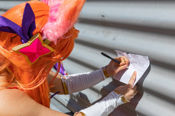 Close up shot of Japanese character from famous comic book. Orange hair, happy festival, good vibes. Petition signing. 