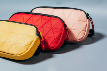 Three waist bags of banana of various colour on a grey background isolation