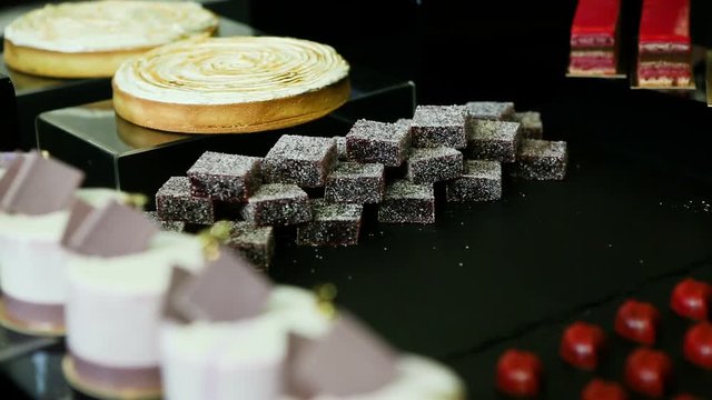 confectioner hand put and take away handmade barry marshmallows in big pyramid at assorted candy bar table