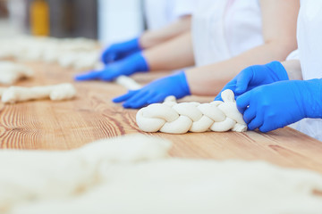 Obraz na płótnie Canvas Woman's hands knead the dough for baking at the bakery