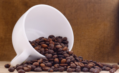 White cup of coffee with coffee beans.