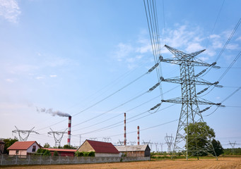 Transmission towers and power plant chimneys in the countryside.