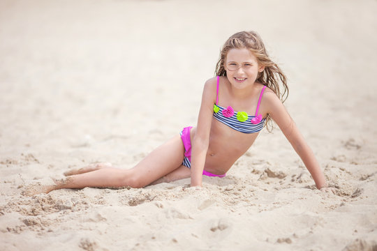 Beautiful young girl relaxing on the beach. Portrait of teen girl on sea sand