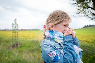 Allergy attack, girl blowing her nose suffering from pollen allergy outdoor 	 - obrazy, fototapety, plakaty