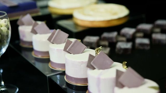 confectioner hands put handmade barry marshmallows in big pyramid at assorted candy bar table