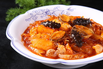 beef stew with carrots and tomatoes in bowl on wooden table