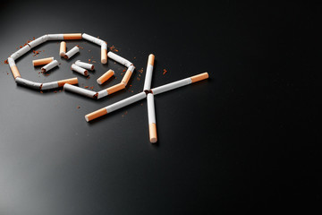 Skull from cigarettes on a black background. The concept of smoking kills. Toward the concept of smoking as a deadly habit, nicotine poisons, cancer from smoking, illness, quit smoking.