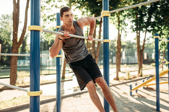 Man doing exercise on horizontal bar outdoor