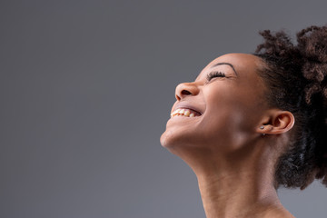 Happy vivacious laughing young African woman - obrazy, fototapety, plakaty
