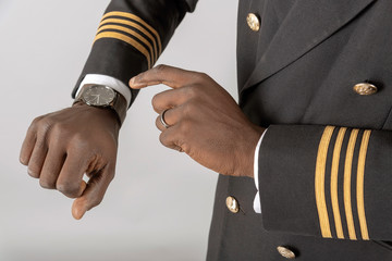 England, UK, April 2019. Airline pilot checking time on his wristwatch.