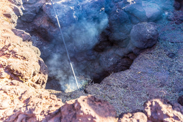 Spain, Lanzarote, Hay bale smoking in heat of geothermal energy of volcano in timanfaya