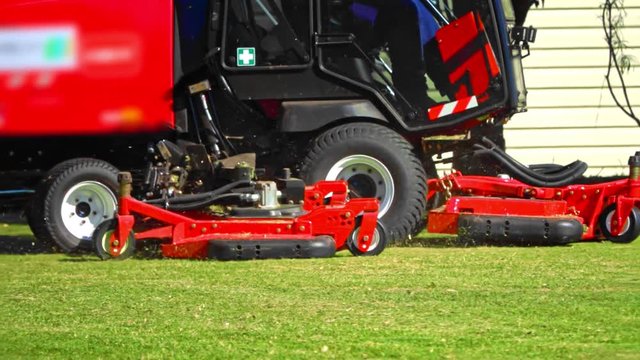 Close up slow motion of commercial lawn mower in the yard