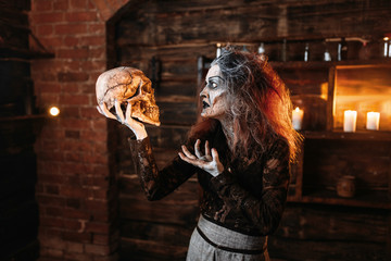 Witch reads the spell, ritual with human skull