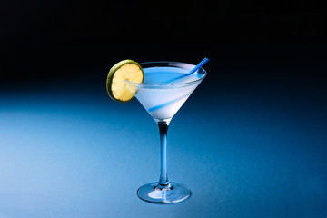 Classic Daiquiri cocktail with lime in martini glass on a dark blue background. Space for text.