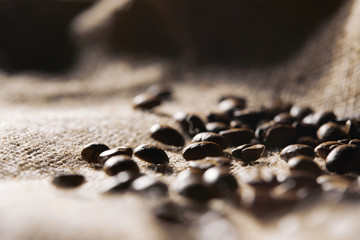 Selective focus of roasted coffee grains on sackcloth texture