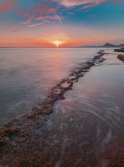 Obraz premium View of a sunset in a mediterranean cove with the last rays of the sun in the seascape