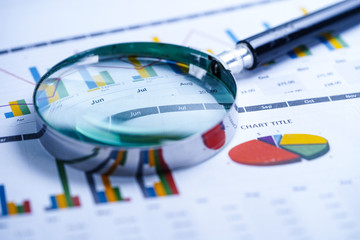Magnifying glass on charts graphs spreadsheet paper. Financial development, Banking Account,...