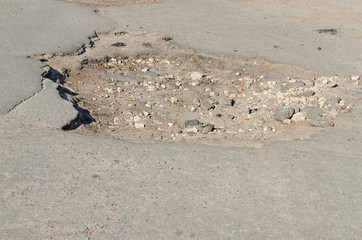 Big pothole on old asphalt road