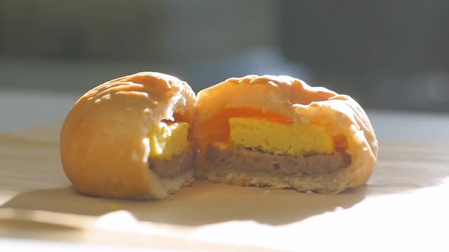 open kolache sausage egg cheese close up. Close up clip of cut open sausage, egg, and cheese kolache.