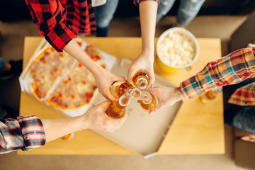 Naklejka na ściany i meble Friends clink bottles over the table with pizza