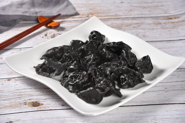 black tea in a bowl on wooden background