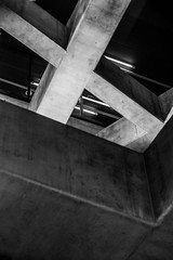 Black and white intersecting concrete beams at subway station