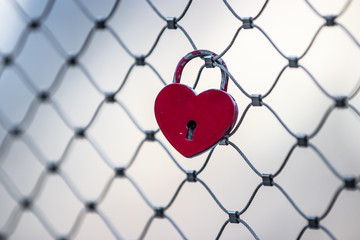 Red heart shaped keylock on a fence