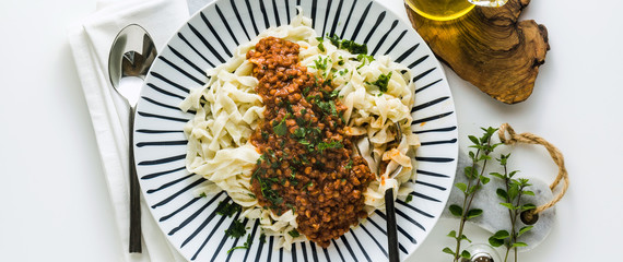 banner of vegan pasta with lentil and tomato sauce in a plate on the table. healthy foodbanner of vegan pasta with lentil and tomato sauce in a plate on the table. healthy food