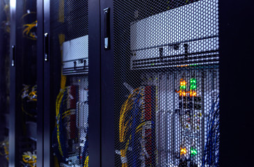 Close up server rack with LED indicator inside under meshed door. Computer server in rack, network and hardware. Inside mainframe.