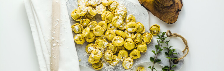 banner of raw ravioli tortellini on the table with flour and rolling pin. cooking healthy italian home cookingini on the table with flour and rolling pin. cooking healthy italian home cooking