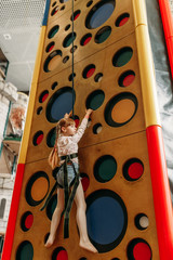 Girl climbing walls in game center, bottom view