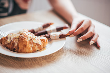 croissant on a plate, candy, hand